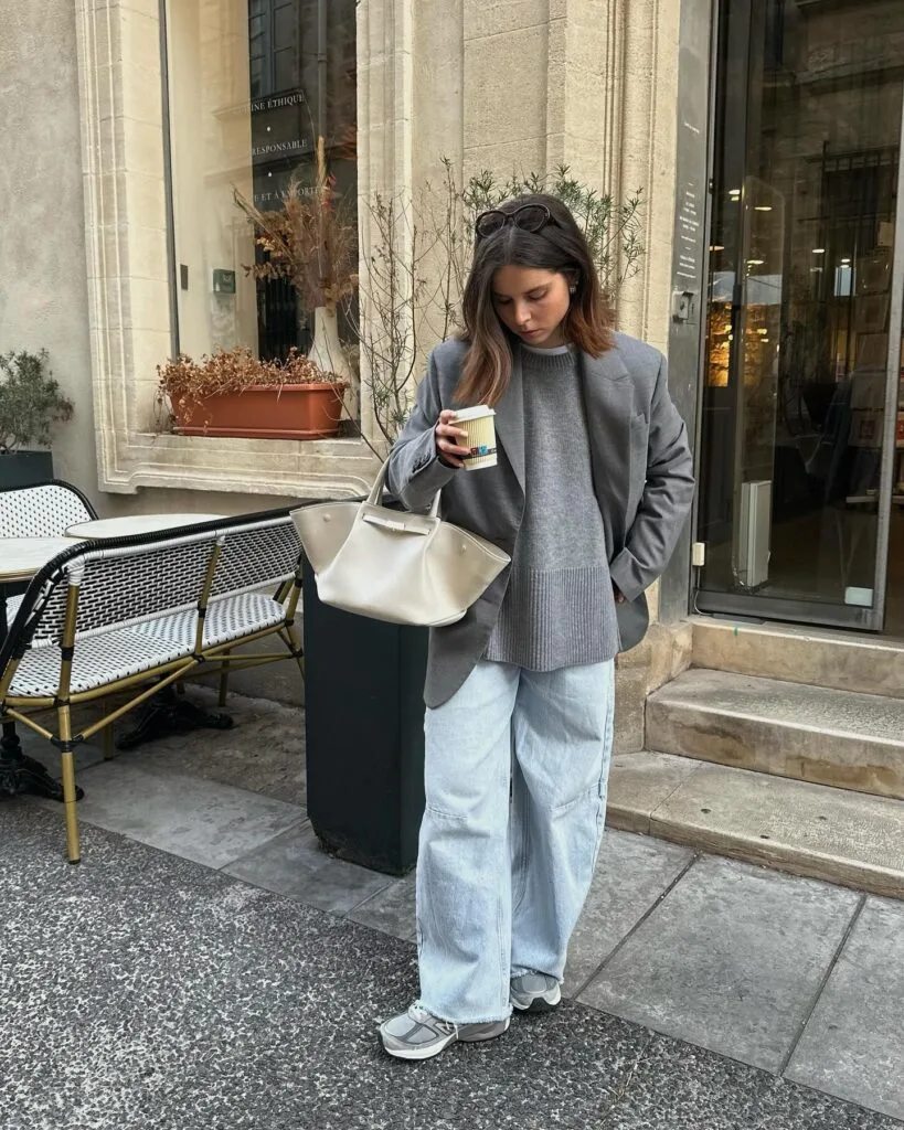 Grey blazer and oversized sweater with light-wash wide-leg jeans and sneakers—easy casual winter outfits look.
