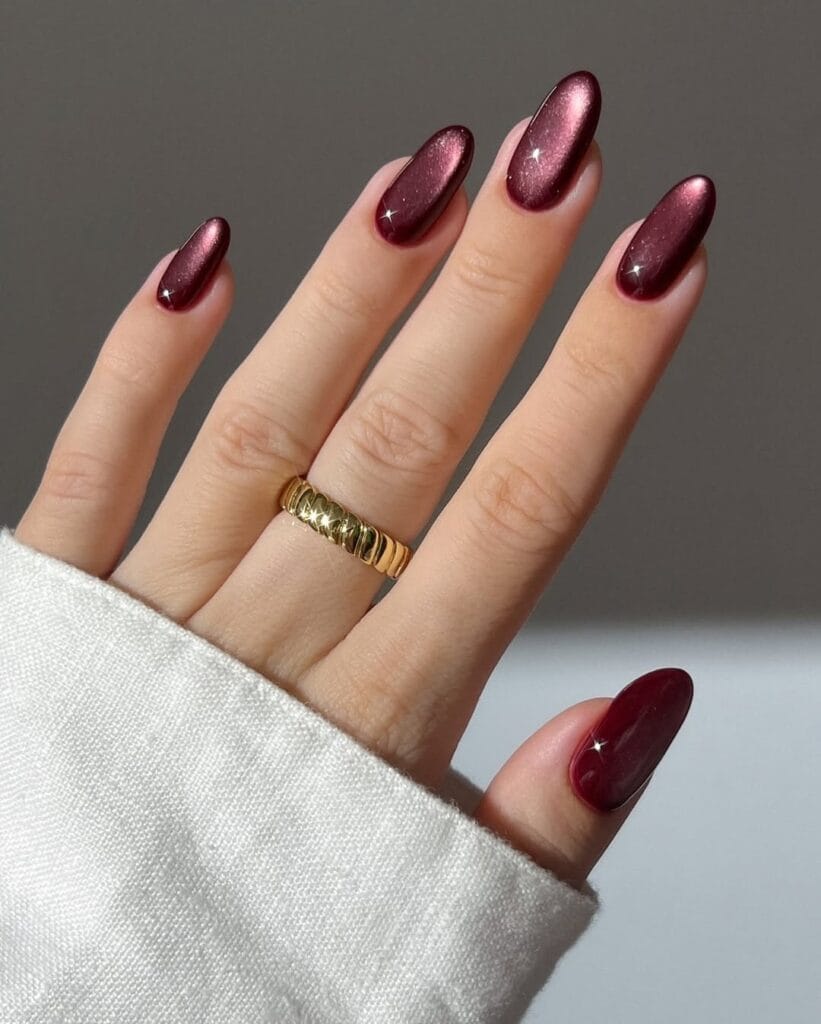 Deep burgundy velvet shimmer nails" winter nail trends, luxe cat-eye manicure