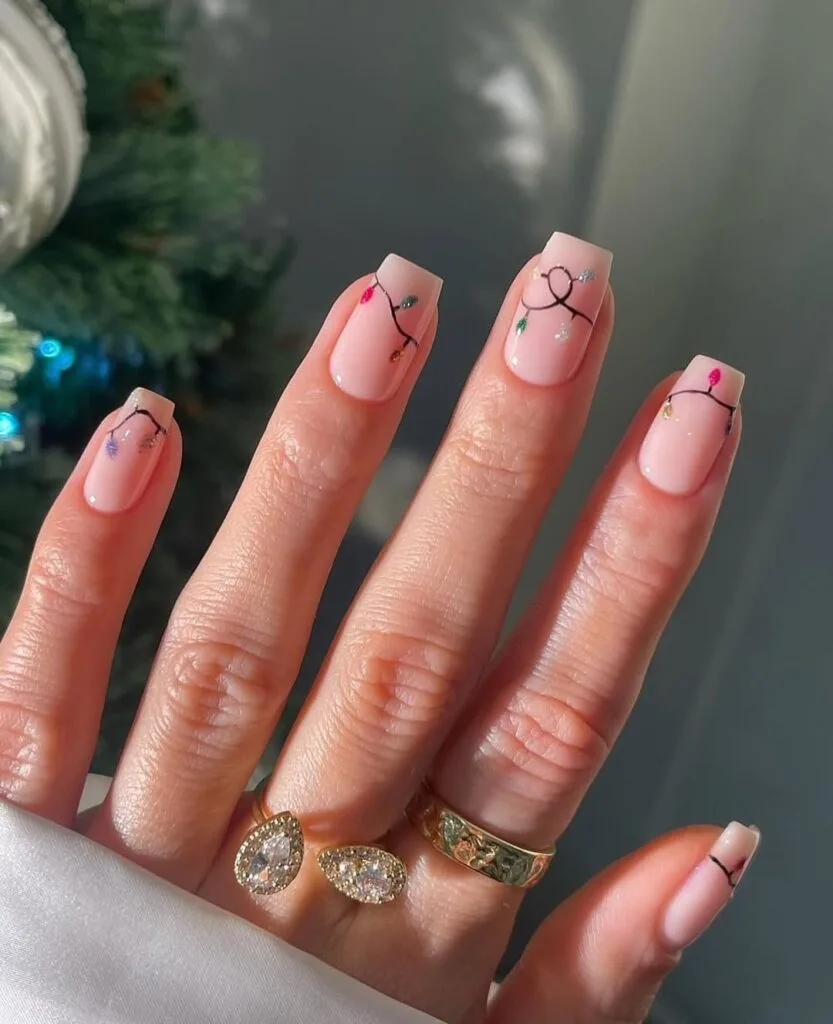 pale pink nails with colorful Christmas light string art, holiday nails
