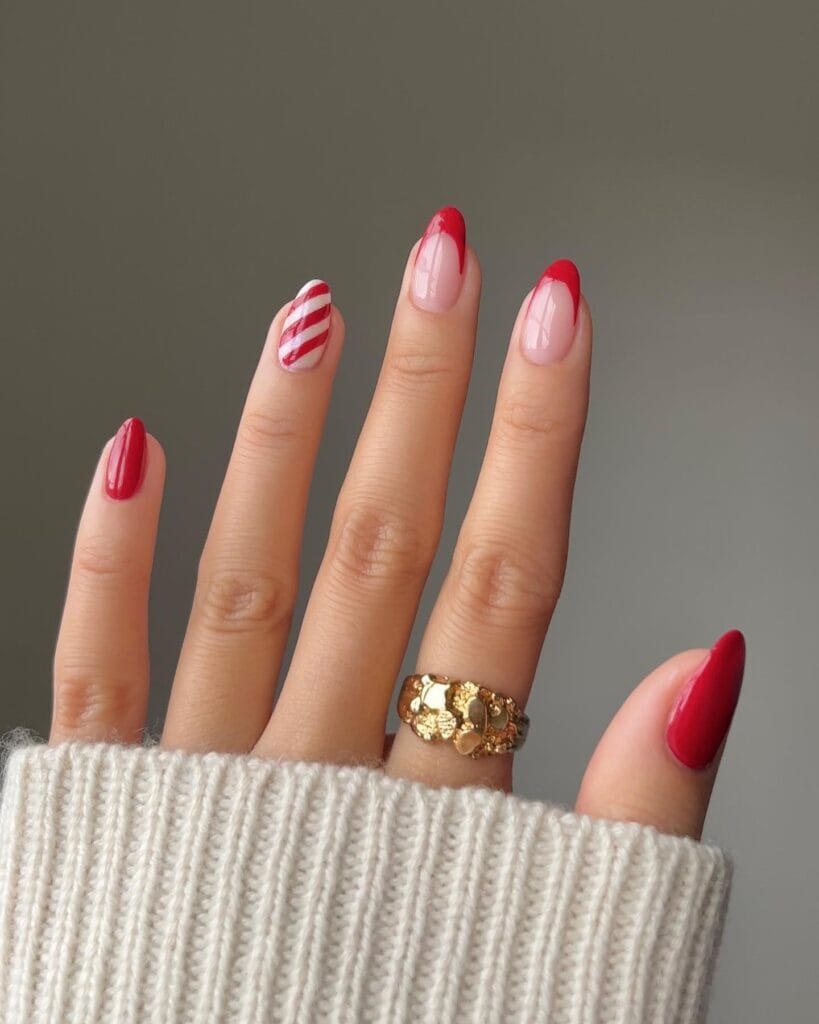 red almond nails with candy cane striped accent, December nail ideas
