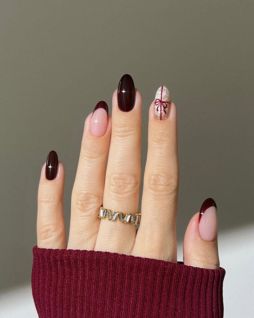 almond nails with deep wine red French tips and glittery gift bow accent, Christmas nails
