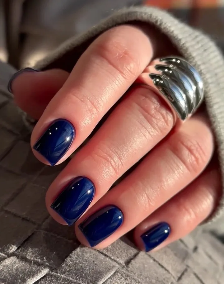 Short glossy navy blue manicure, simple winter nails.