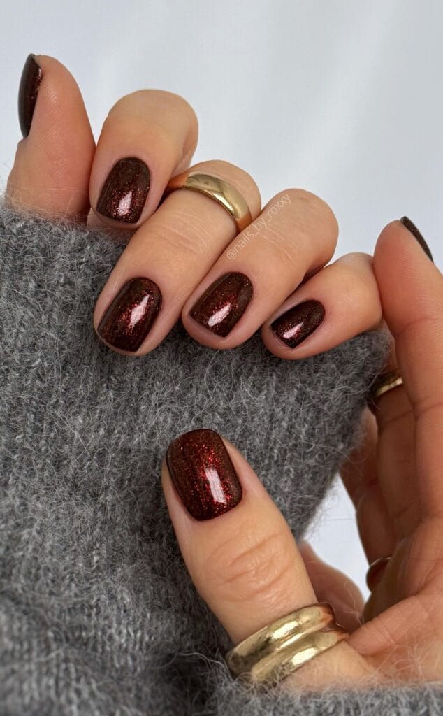 short winter nails in burgundy with red copper glitter shimmer, square shape, gold rings