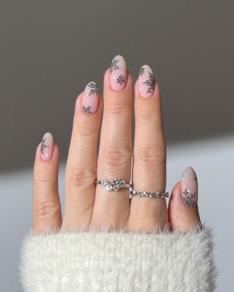 sheer pink nails with silver glitter snowflakes, winter Christmas nail art