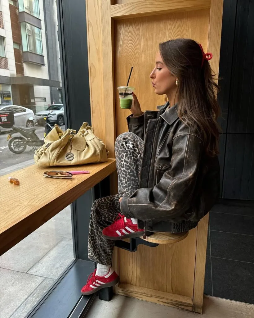 Brown leather jacket with leopard print pants and red sneakers—fun casual winter outfits for weekends.
