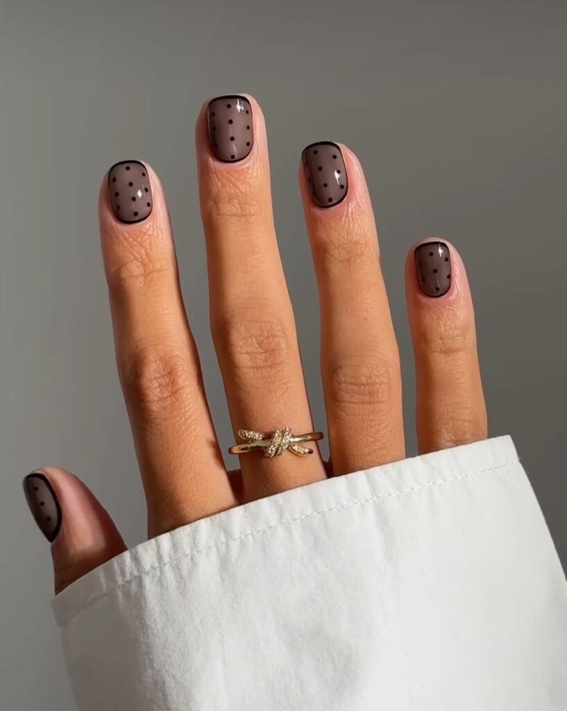 Short chocolate nails with sheer black polka dots" winter nail trends, subtle polka dot mani