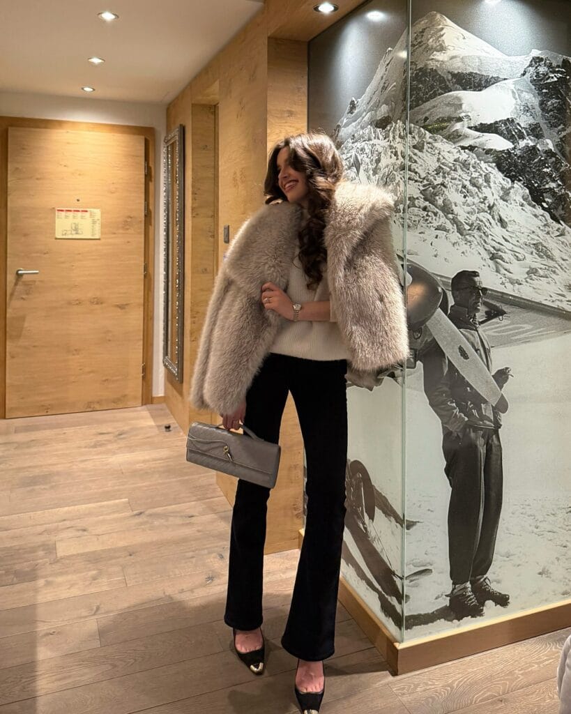  winter date outfit with beige fur coat, cream sweater, black pants, heels
