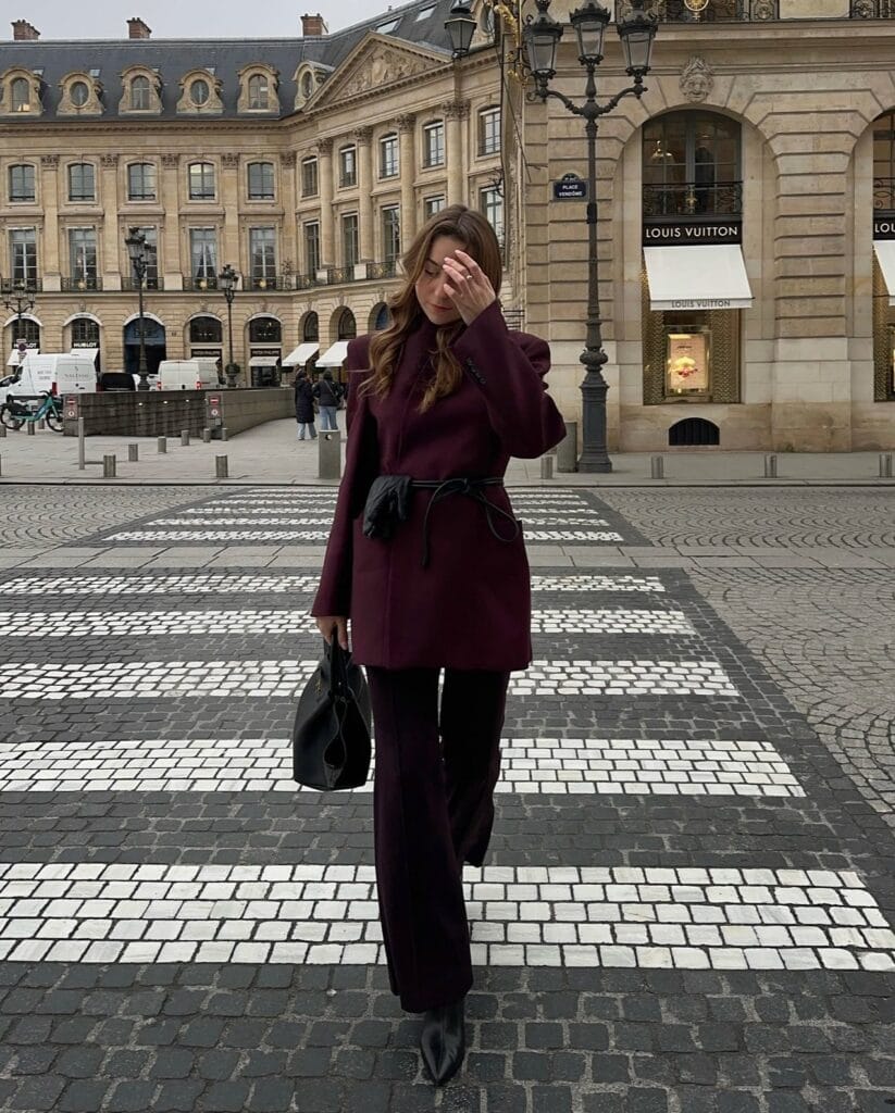 Deep burgundy blazer and pants set, belted at the waist, Belted & Cinched trend, crosswalk scene.