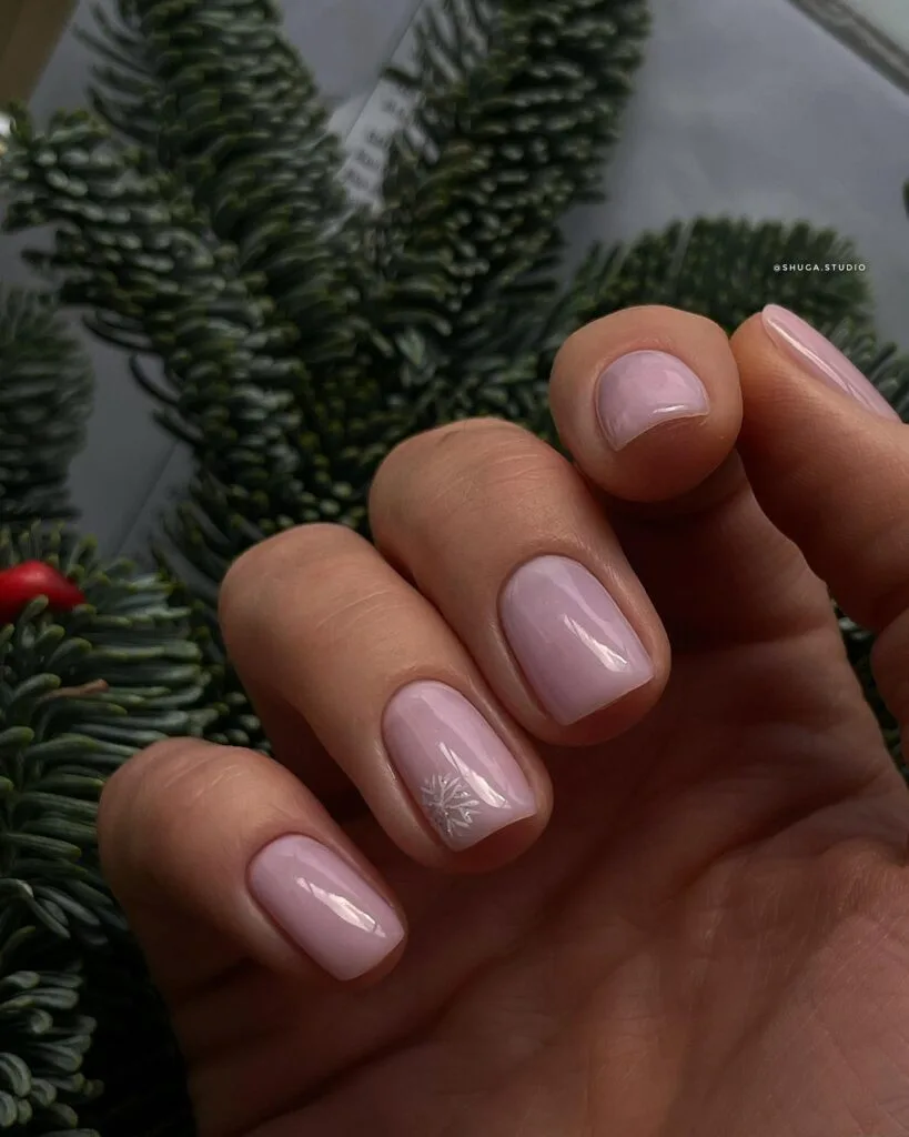 Simple winter nails with light lilac polish and one tiny snowflake accent on short nails.