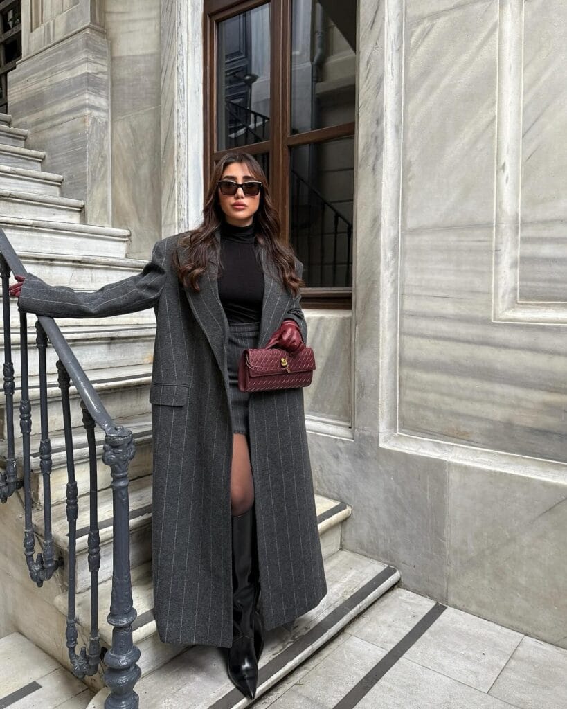 winter date outfit with charcoal pinstripe coat, black mini skirt, boots
