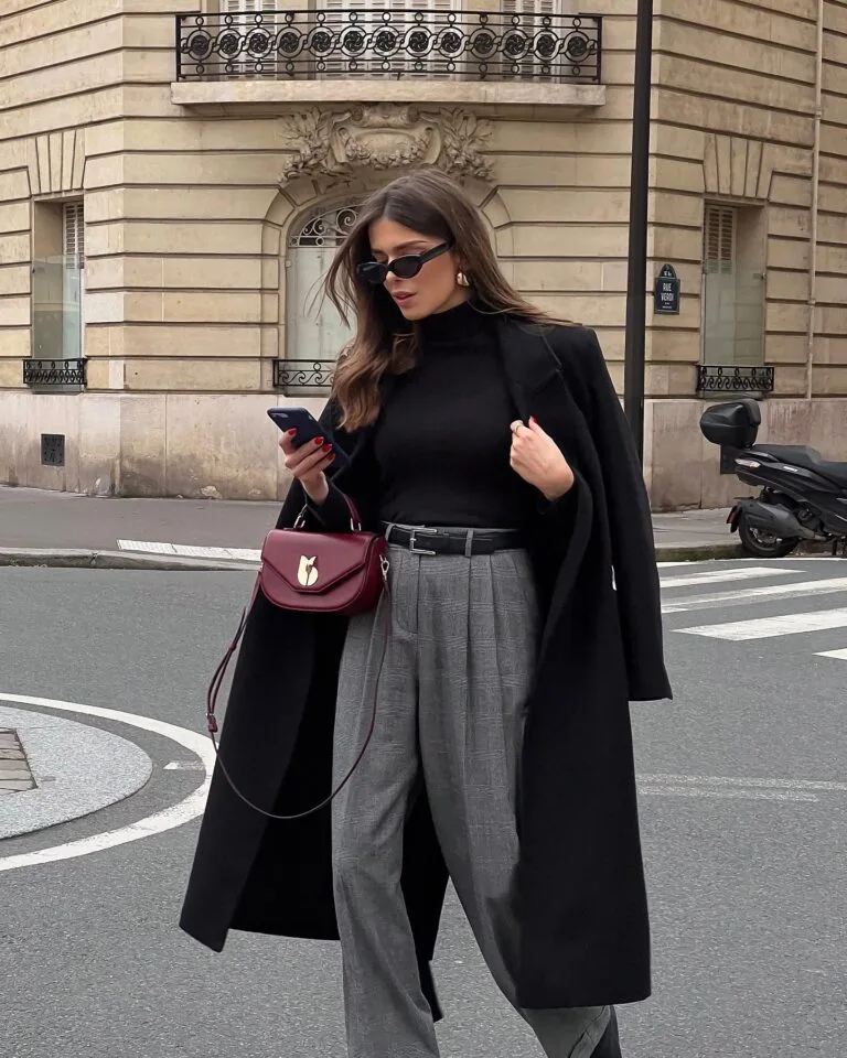 winter work outfit with black coat, black turtleneck, grey plaid trousers, burgundy handbag, black belt