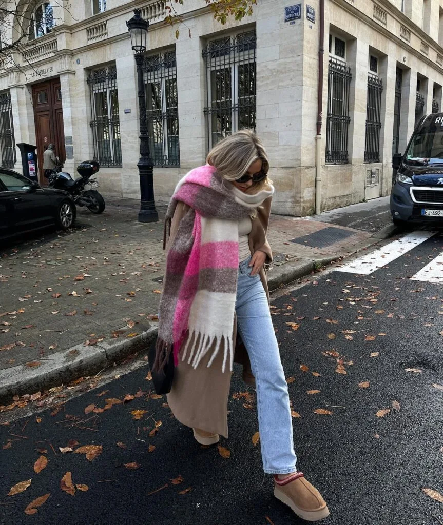 Camel coat with oversized pink plaid scarf, light jeans and tan clogs—cozy casual winter outfits inspiration.