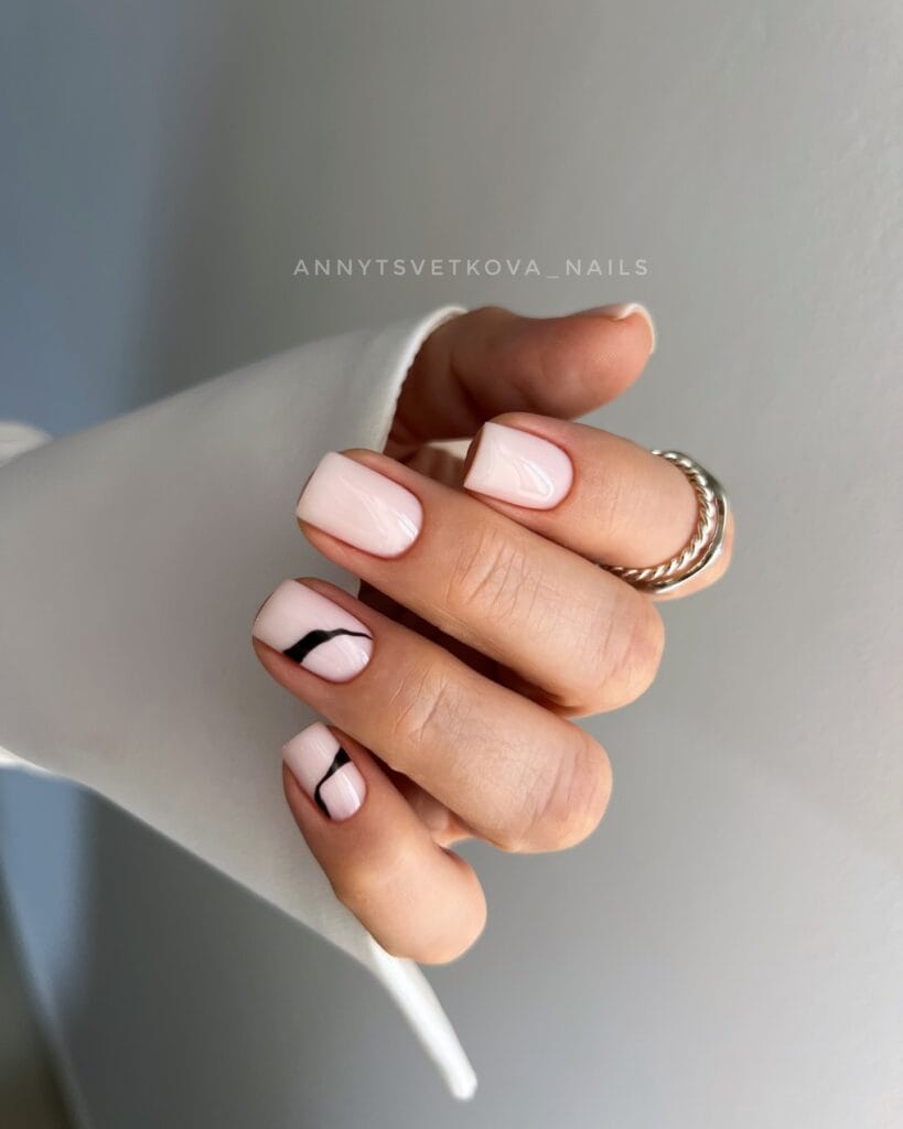 January nails: milky blush short square nails with two black wavy line accents.
