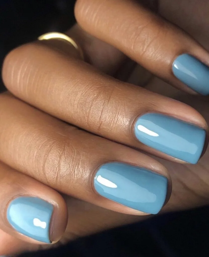 trendy nails in soft dusty blue, short square shape with glossy finish and gold ring