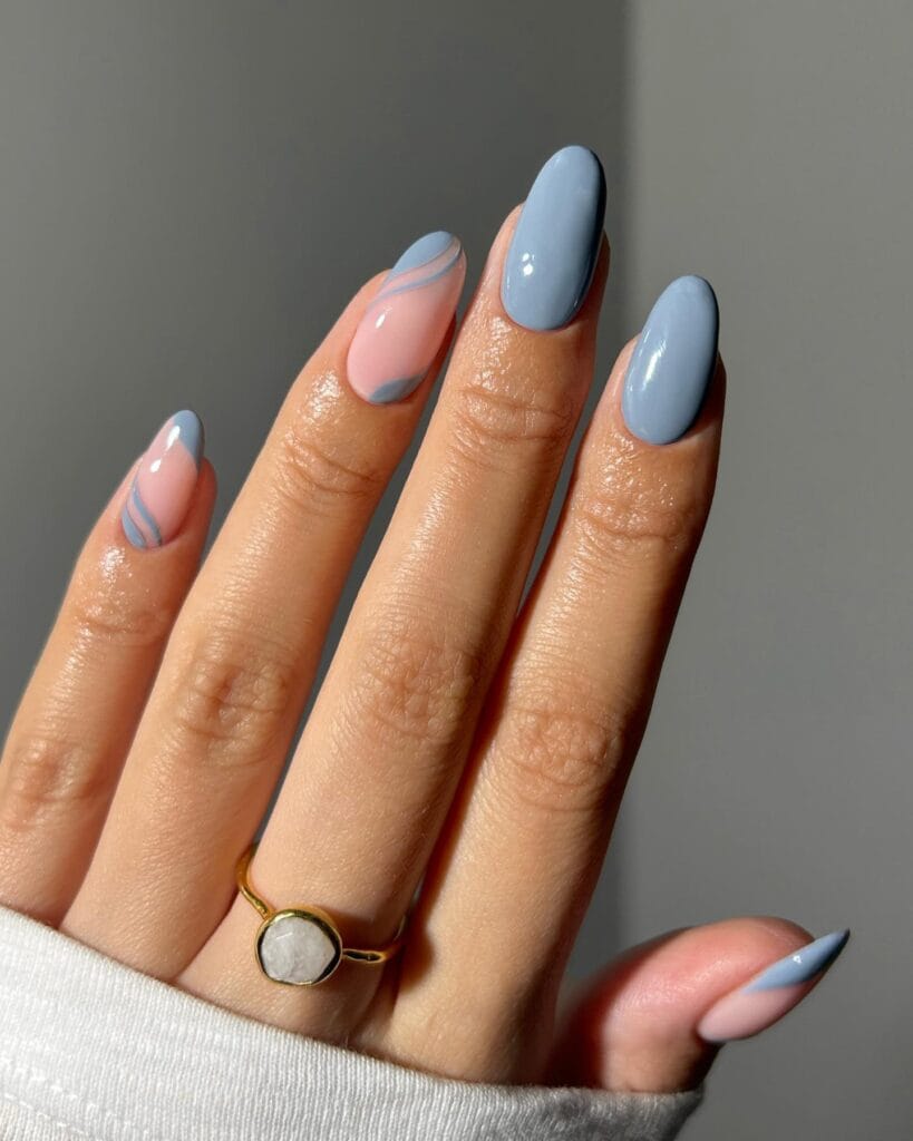 fog blue almond nails with pink and blue swirl design, gold ring with white stone