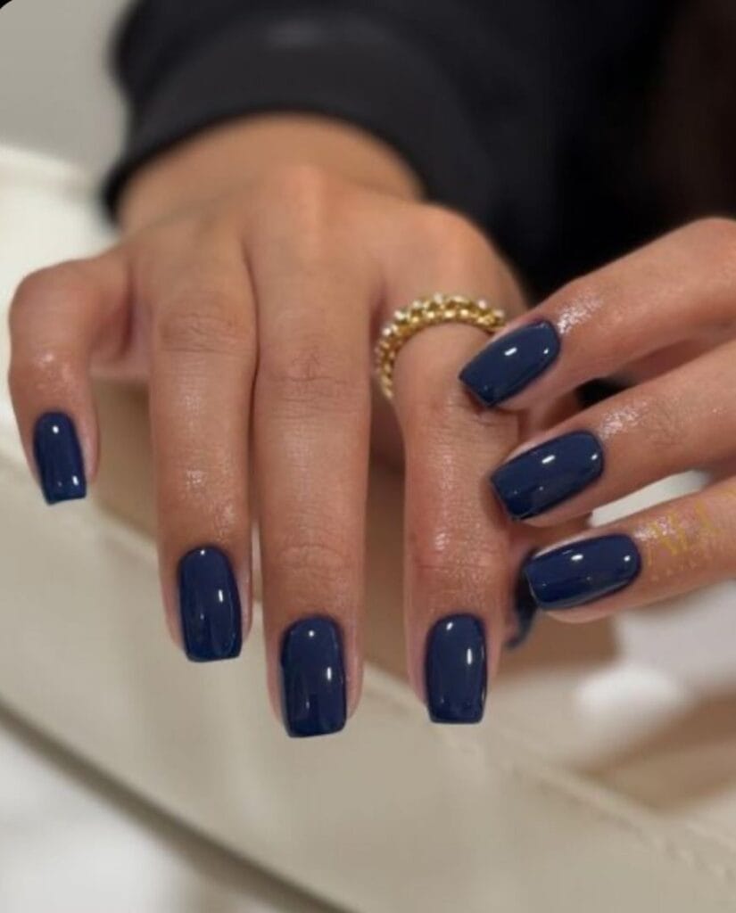 nail colors for 2026, short square nails in deep navy blue with gold beaded rings