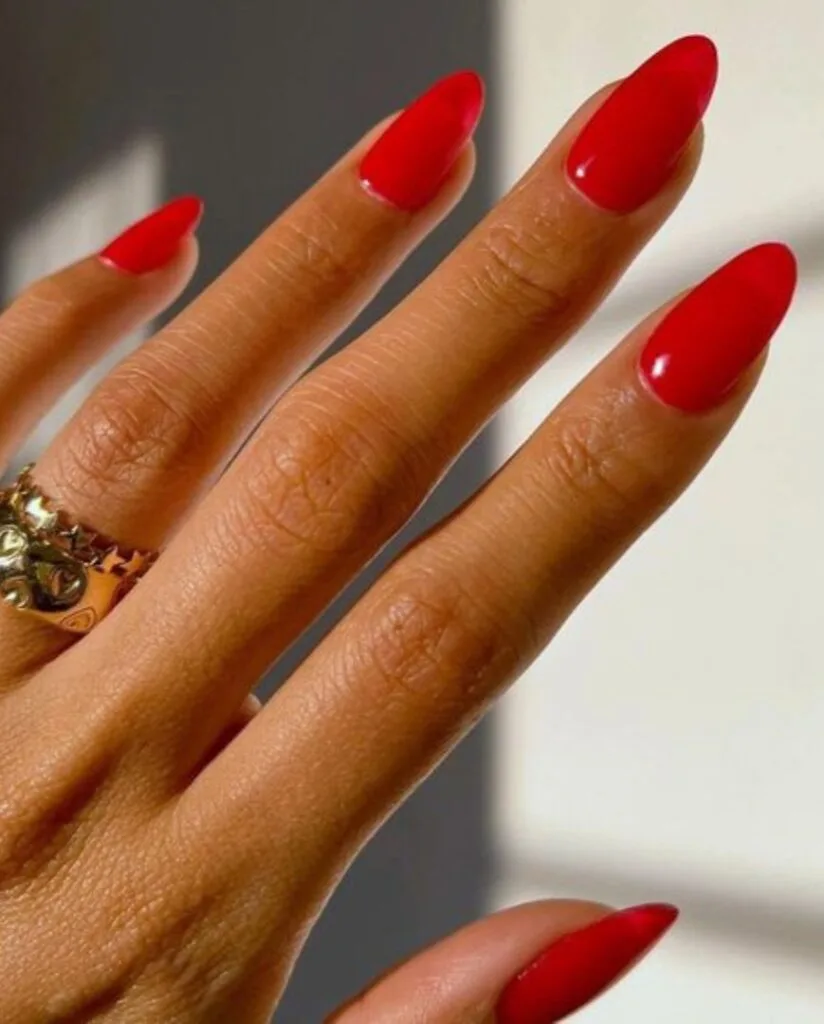 nail colors for 2026, almond nails in bright orange-red with gold statement rings