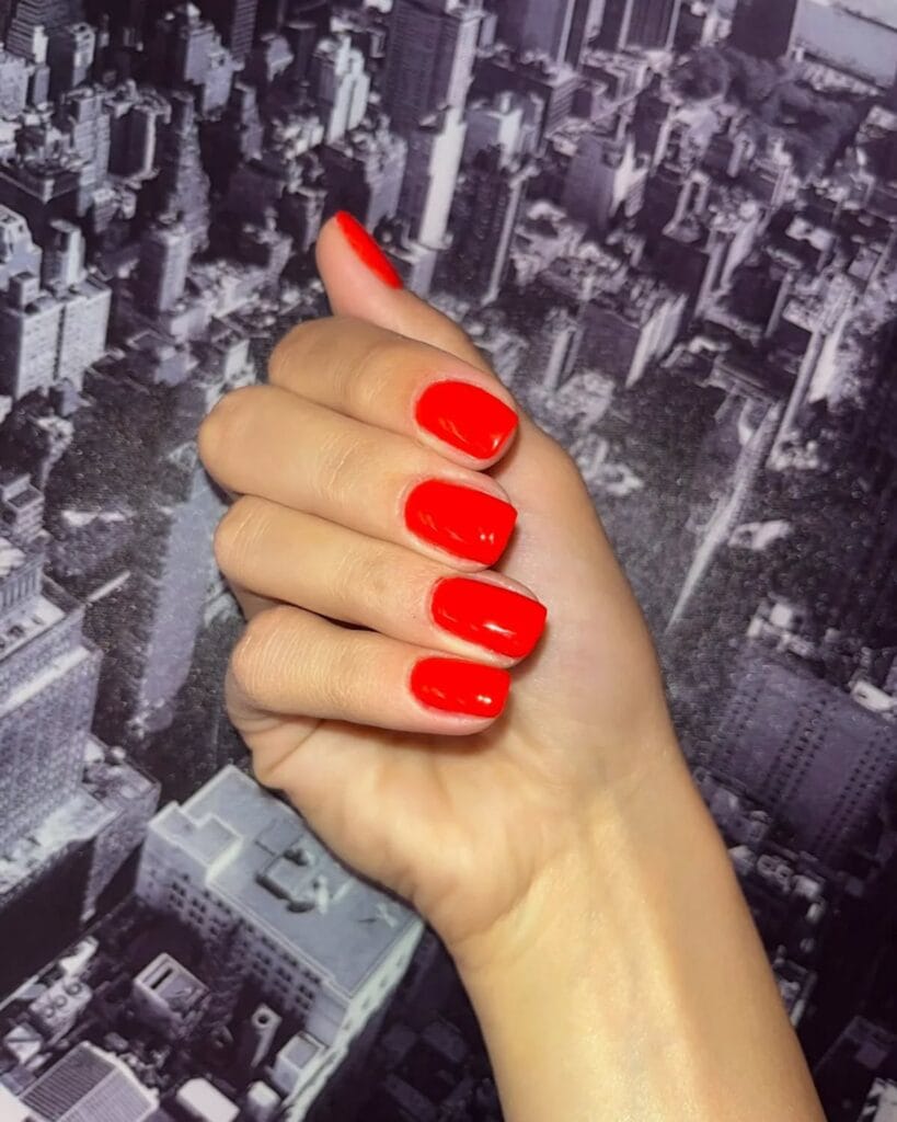 trendy nails in poppy red, short square shape with glossy finish