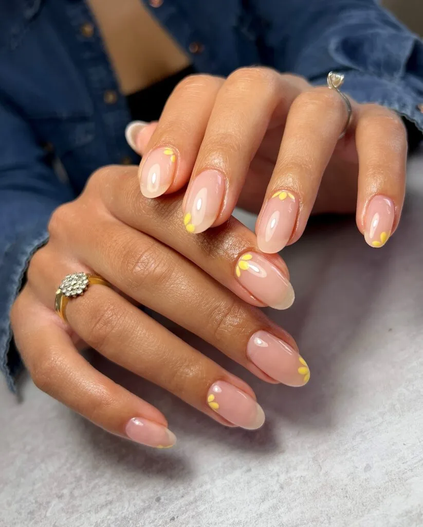 2026 nail trends, delicate yellow daisy details on nude oval nails with silver ring