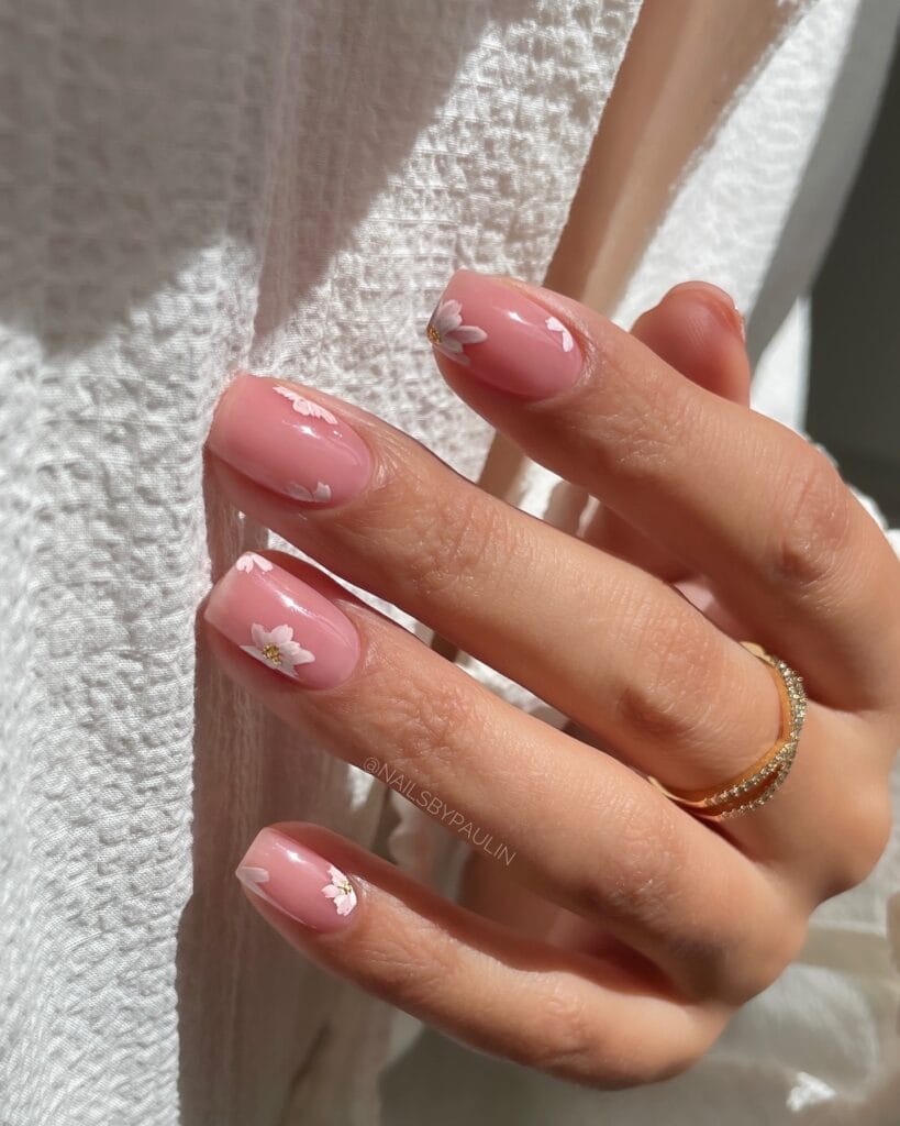 2026 nail trends, tiny white floral accents on pink oval nails