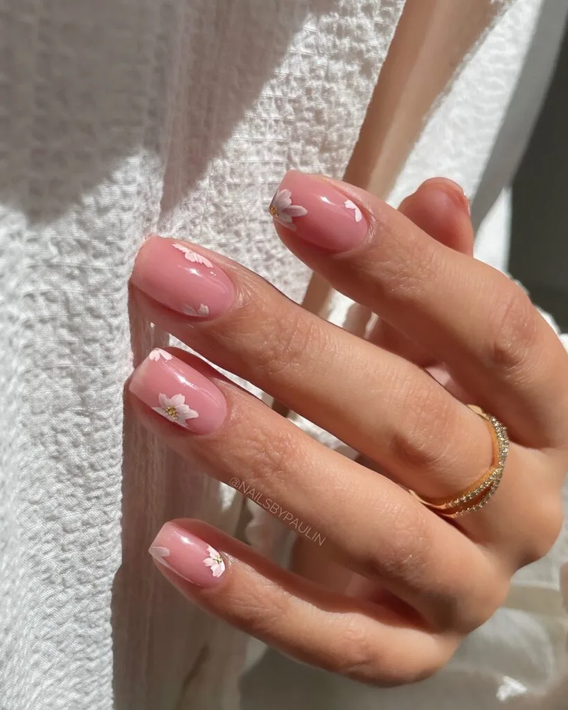 2026 nail trends, tiny white floral accents on pink oval nails