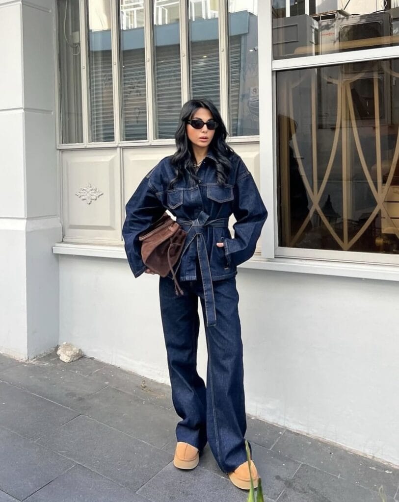 2026 fashion trends, dark denim belted jacket with wide-leg jeans, brown clutch, platform shoes