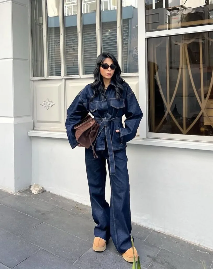 2026 fashion trends, dark denim belted jacket with wide-leg jeans, brown clutch, platform shoes