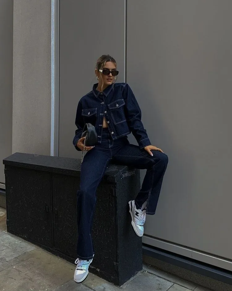 2026 fashion trends, dark denim jacket with matching wide-leg jeans, white sneakers, denim-on-denim look