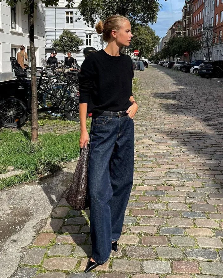 fashion trends 2026, black sweater with dark raw denim wide-leg jeans and brown tote bag