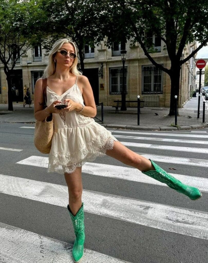 fashion trends 2026, white lace mini dress with green cowboy boots, romantic feminine styling