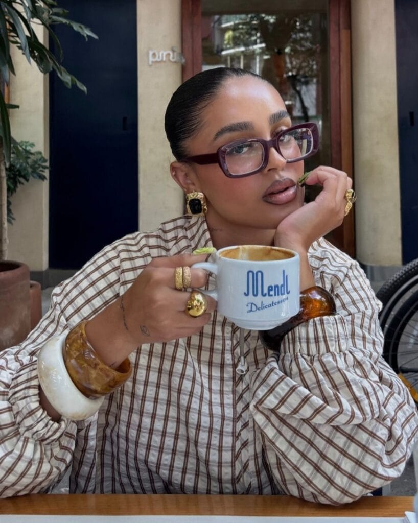 2026 fashion trends, bold gold statement earrings with black stones, chunky textured gold rings, oversized glasses