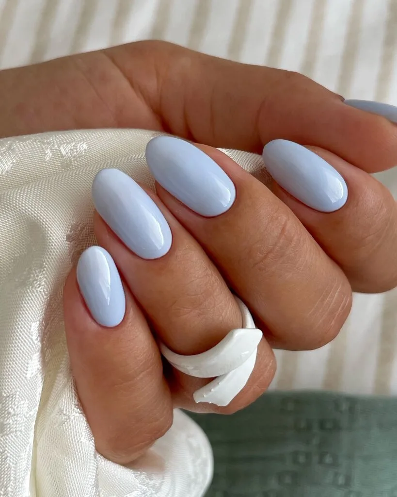 spring nail colors 2026, soft sky blue glossy almond nails with white ring