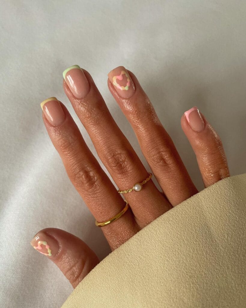 classy spring nails, short square nude nails with pastel French tips and abstract heart accents