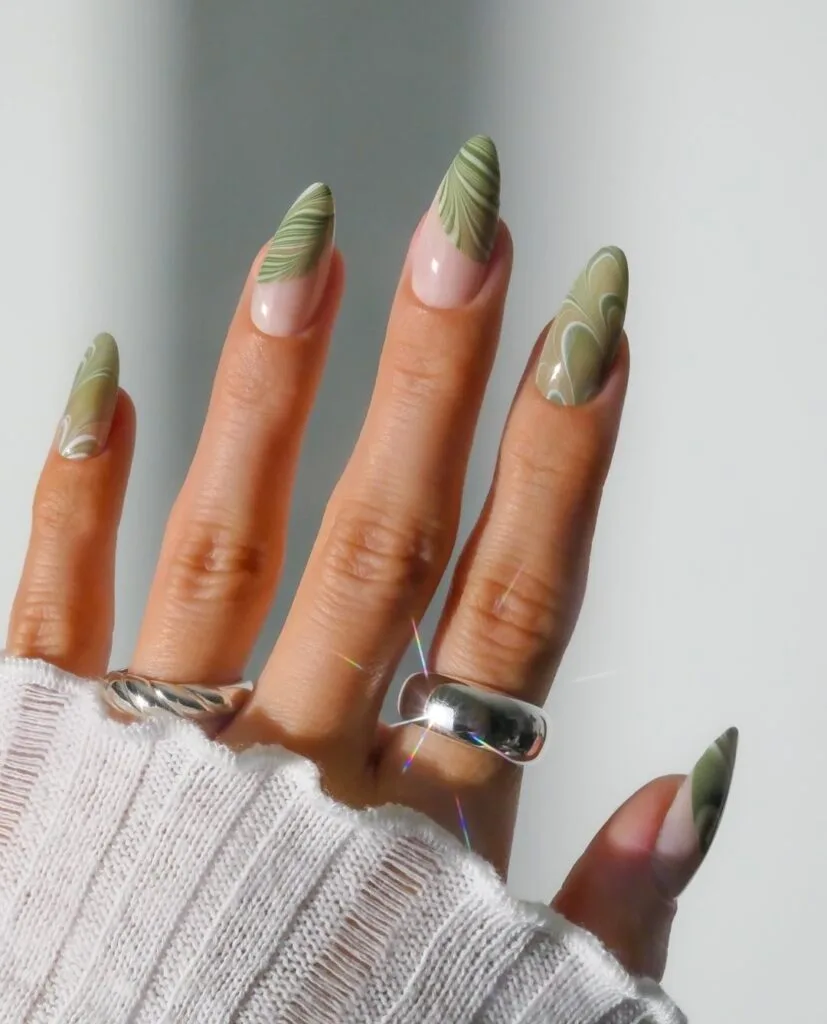 spring nail trends 2026, sage green swirl nail art on almond nails with nude base
