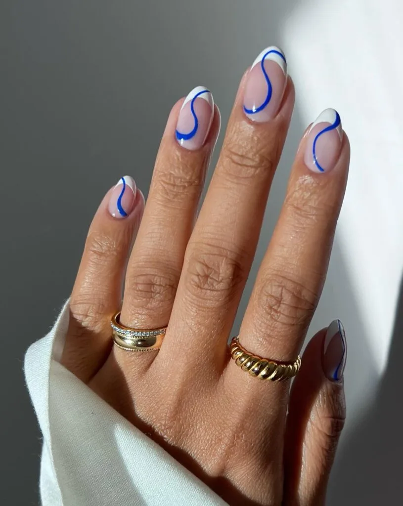 spring nail trends 2026, blue swirl lines on sheer almond nails with white French tips