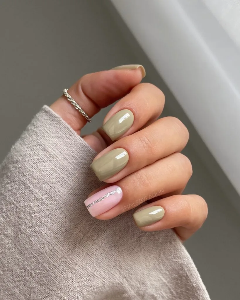 spring nail colors 2026, sage green short square nails with pink accent nail and glitter detail