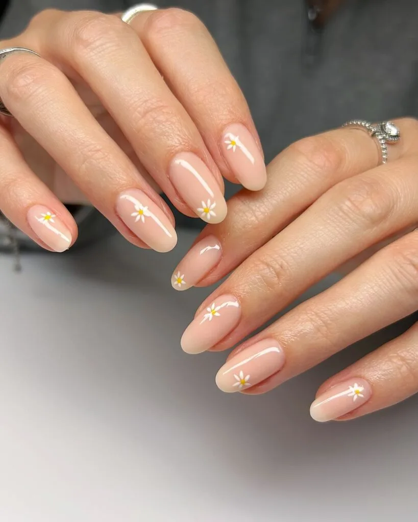 spring nail trends 2026, nude almond nails with tiny daisy flower accents