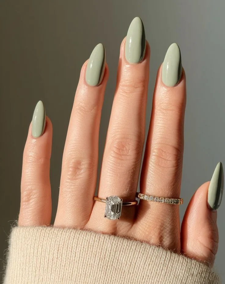 spring nail colors 2026, sage green almond nails with gold rings, glossy finish