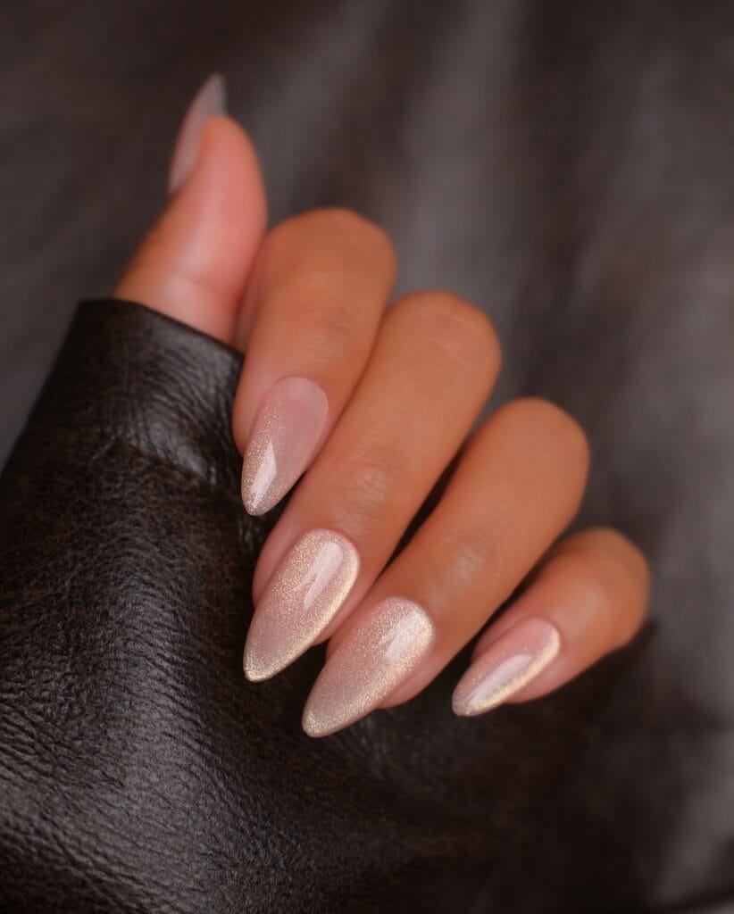spring nail colors 2026, champagne shimmer almond nails with golden glitter finish
