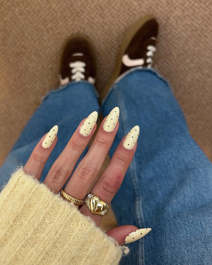 spring nail trends 2026, butter yellow almond nails with small black polka dots
