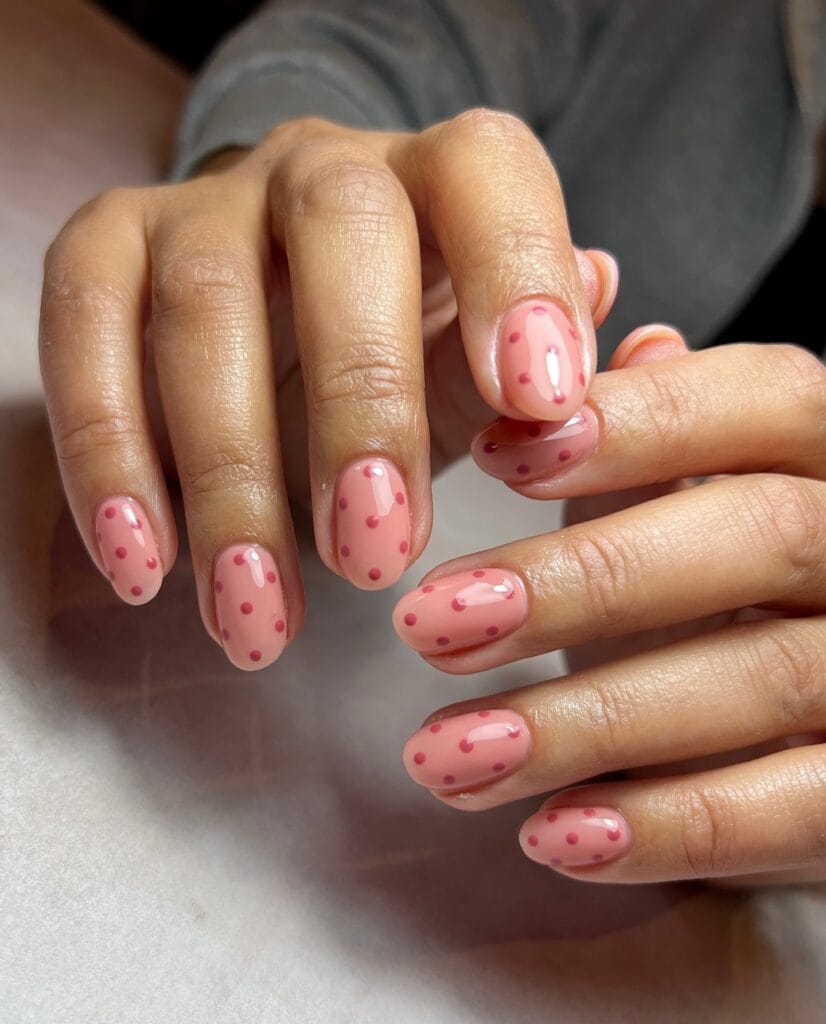 spring nail trends 2026, pink round nails with darker pink polka dots, glossy finish