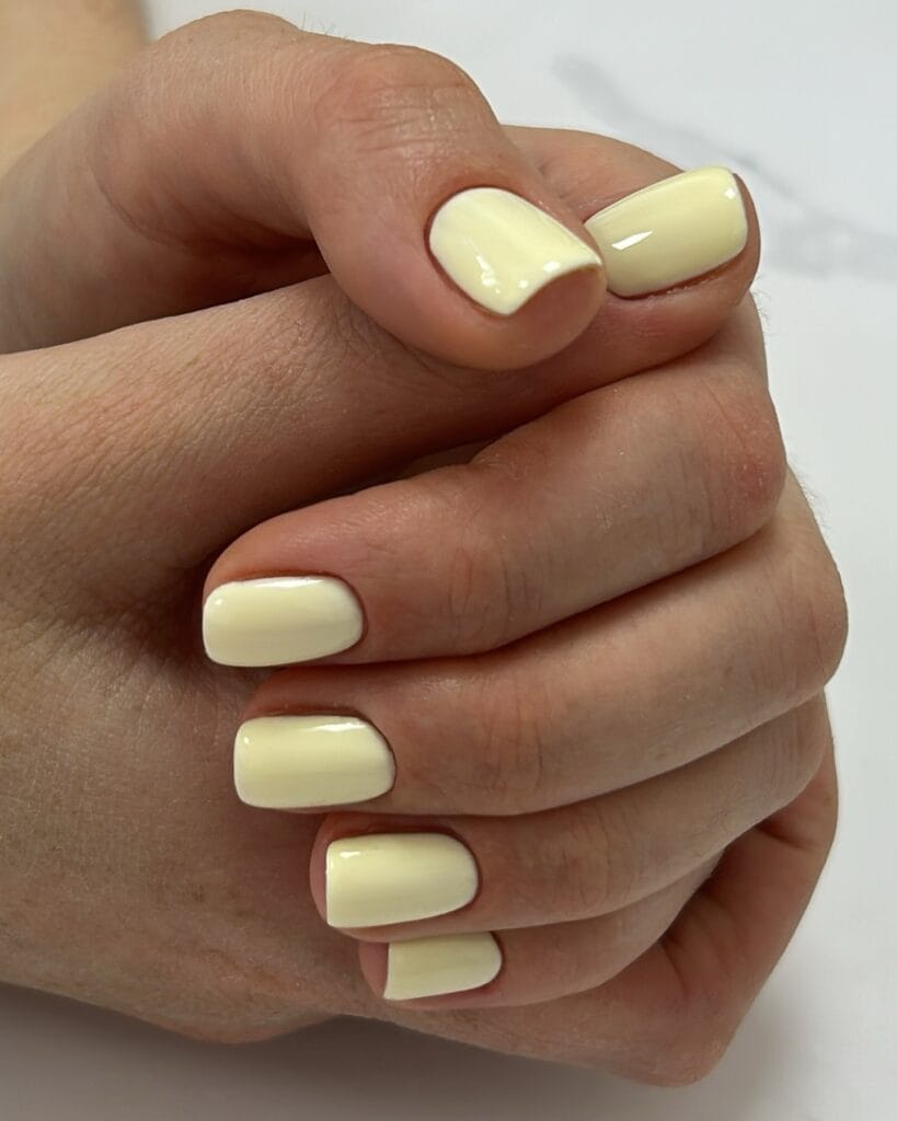 spring nail colors 2026, butter yellow short square nails, glossy finish, both hands
