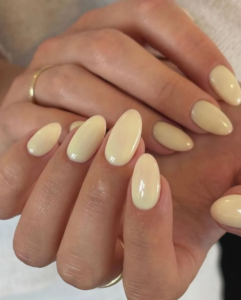 spring nail colors 2026, creamy butter yellow almond nails, glossy finish