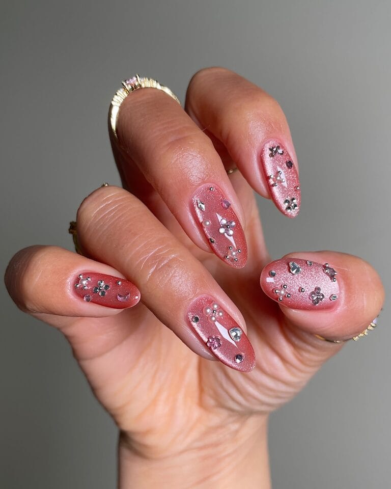 spring nail trends 2026, pink shimmer almond nails with gem clusters and pearl accents