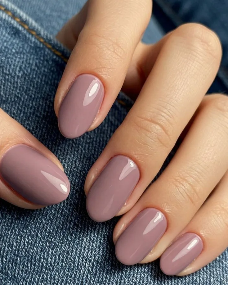 spring nail colors 2026, dusty mauve short round nails, glossy finish, denim background