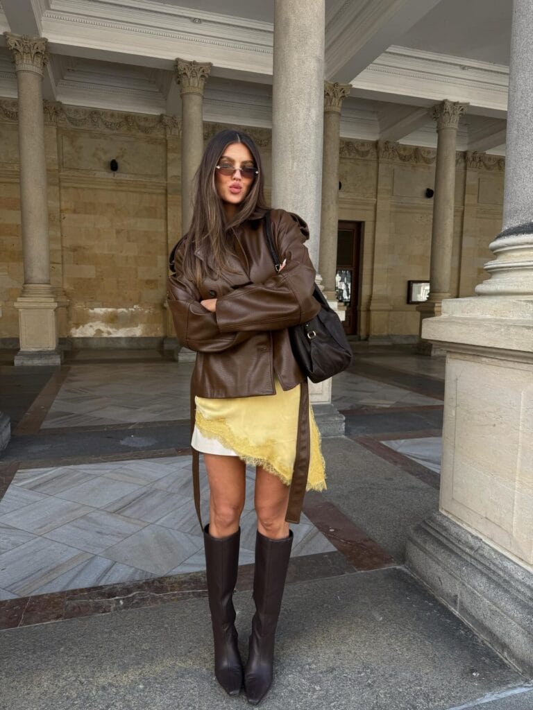 may outfit with brown leather jacket, gold satin mini skirt with lace trim, and tall brown boots
