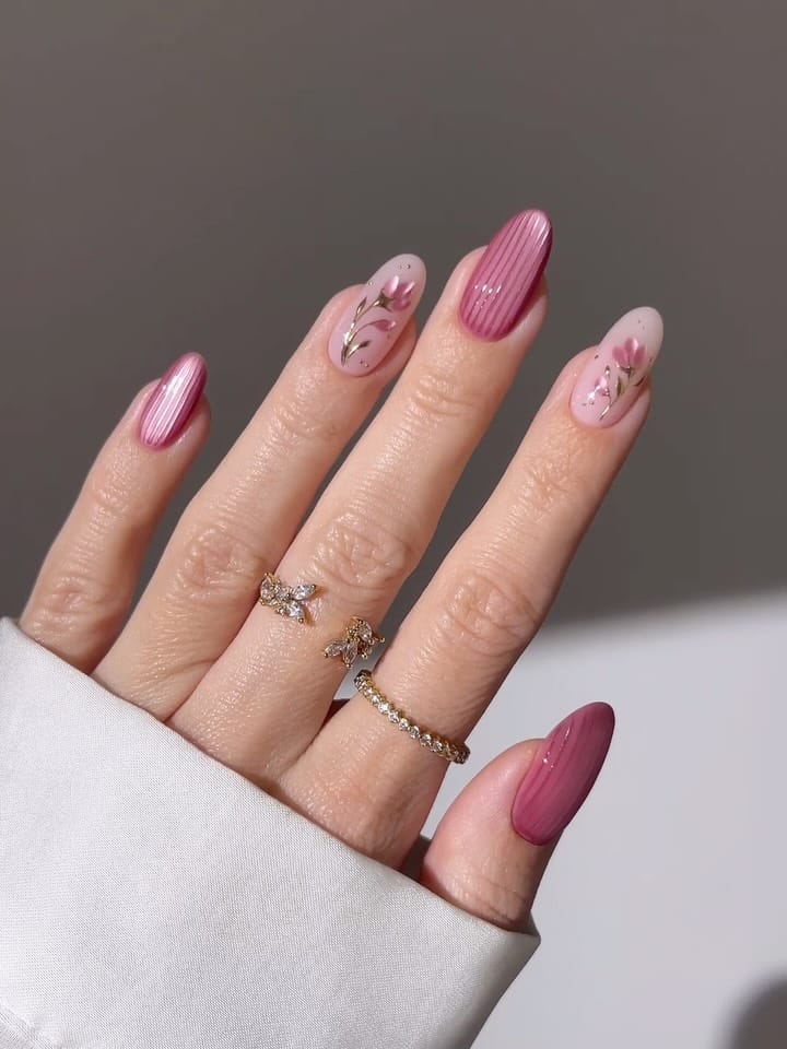 may nails, almond dusty rose velvet nails with pink pinstripes, sheer floral art, and gold leaf accents
