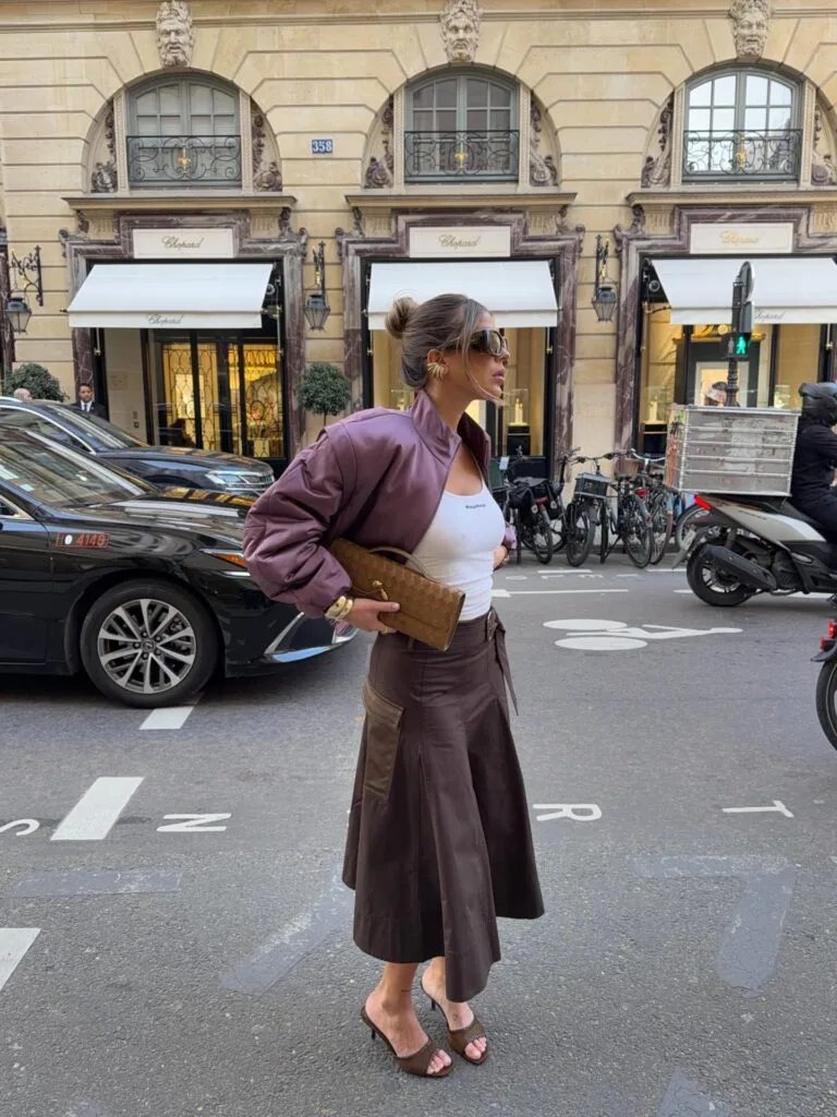 may outfit with plum bomber jacket, white tank top, brown leather midi skirt, and brown slide sandals
