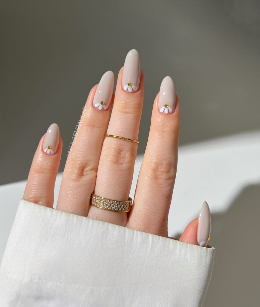 simple spring nails, almond nude nails with white daisy petal cuticle art and gold center dots