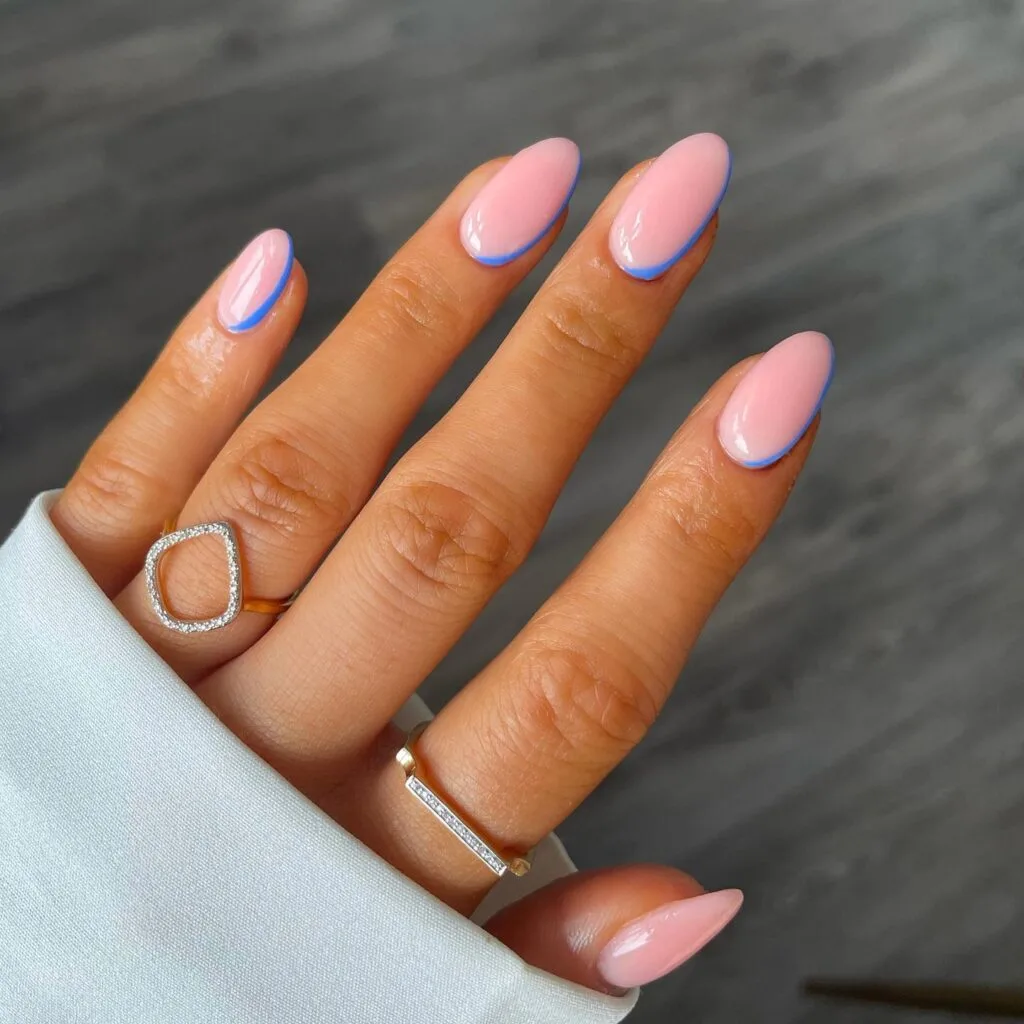 simple spring nails, almond pink nails with thin blue outline accent along the nail edge
